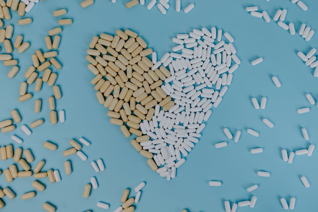 Home Heart-shaped design made of pills and tablets on a blue background, symbolizing health and medicine.